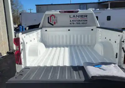 Decal on the window of a Lanier Custom Homes & Restoration truck with the phone number and logo